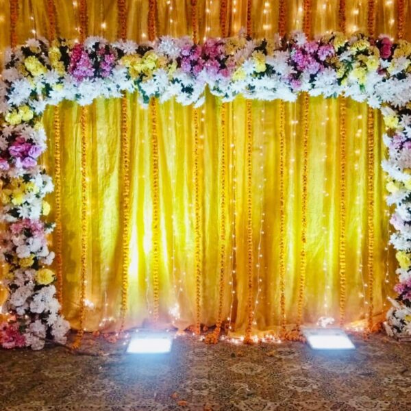Floral Wedding Backdrop with Yellow Drapes & String Lights